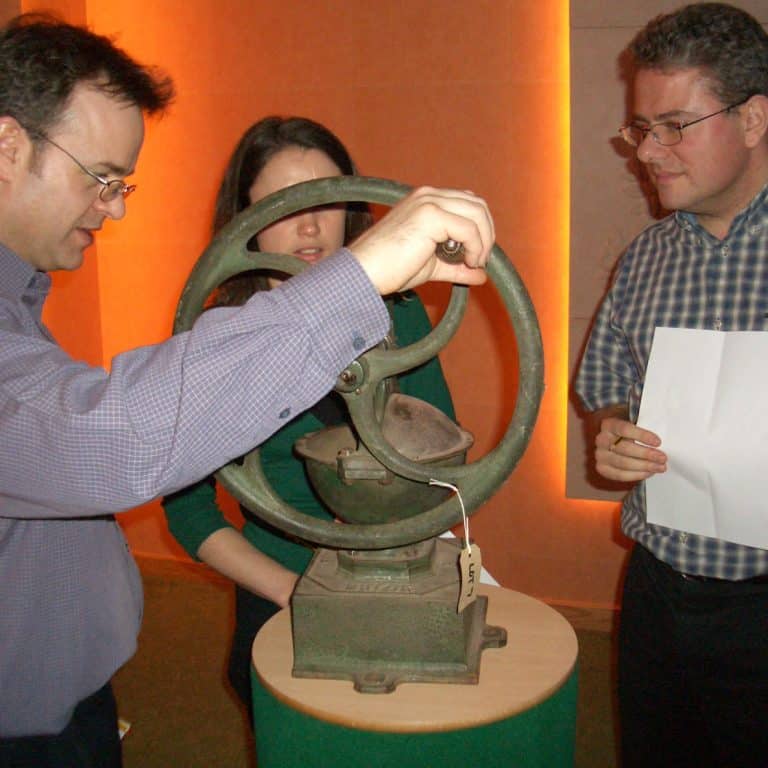 Delegates looking at and taking notes on one of the antiques used as part of Orangeworks team building activity called The Curio Show.