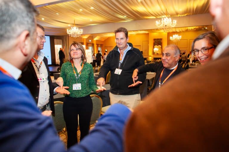Delegates from Zoetis standing in a circle playing one of Orangeworks quickfire challenges.