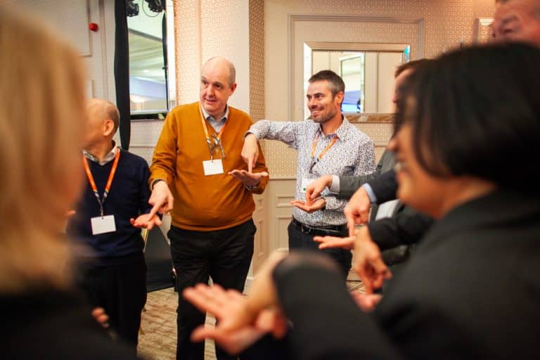 Delegates from Zoetis standing in a circle playing one of Orangeworks quickfire challenges.