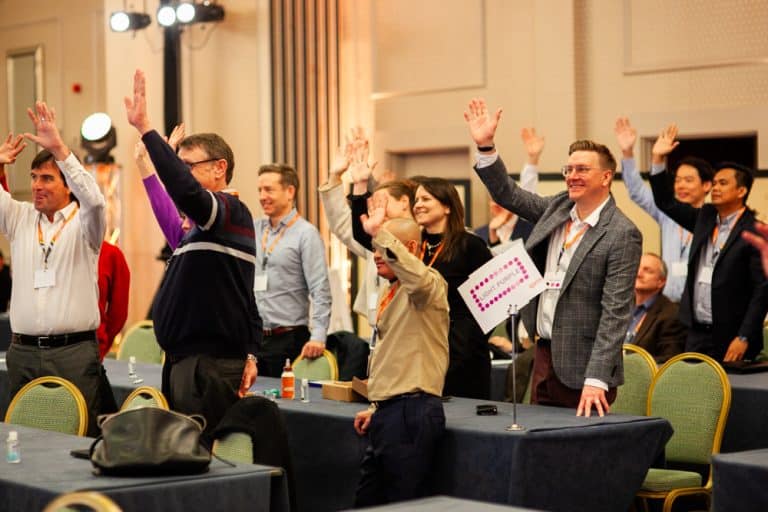 Delegates raising their hands during Orangeworks CSR based team building challenge 'The Green Game'.