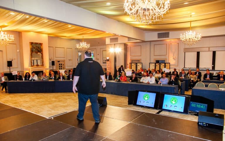 Oddie, Orangeworks MC explaining to delegates how The Green Game team building activity works.