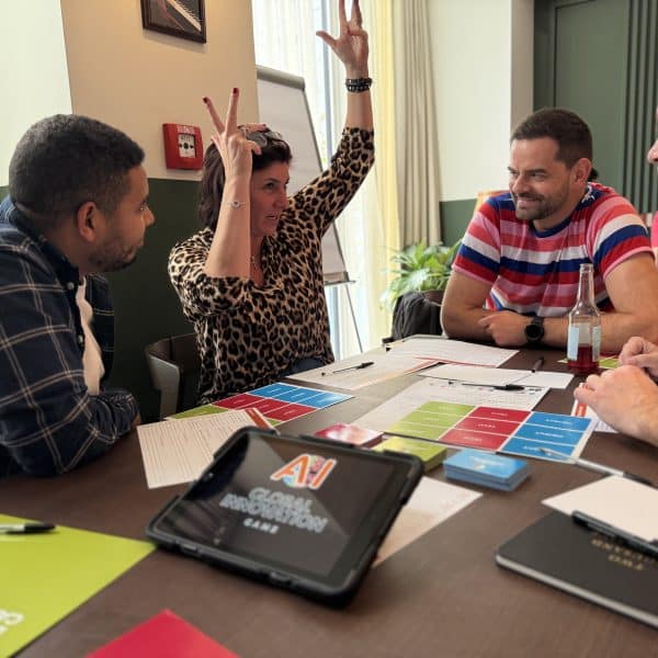 Delegates sitting around a table discussing their ideas for Global Innovation Game - one of Orangeworks team development activities.
