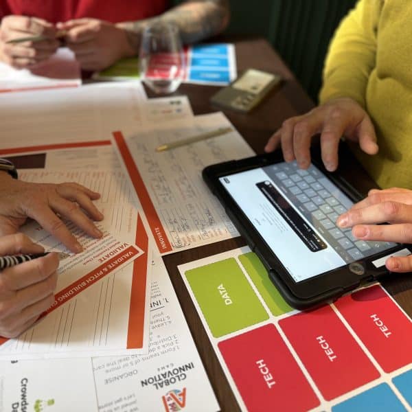 A delegate typing on an ipad during their ai assisted activity with Orangeworks called Global Innovation Game