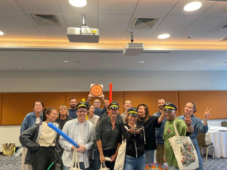 Delegates participating in one of Orangeworks fun team development activities called Drone Control. The aim of the activity is to successfully fly drones through man-made obstacles.