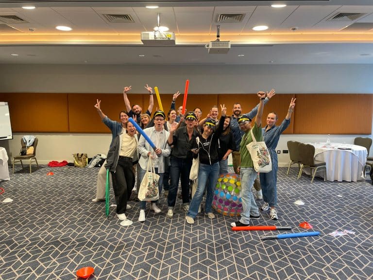 Delegates participating in one of Orangeworks fun team development activities called Drone Control. The aim of the activity is to successfully fly drones through man-made obstacles.