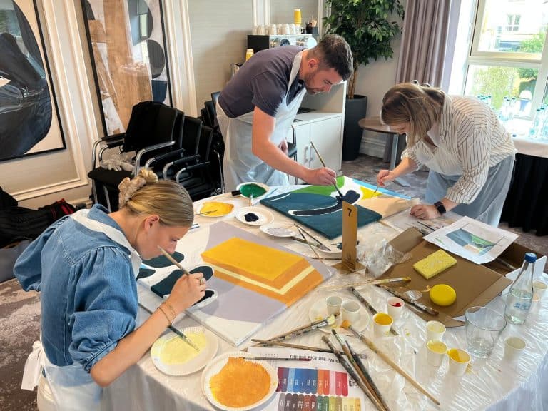 Delegates painting canvases as part of Orangeworks team activity called The Big Picture.