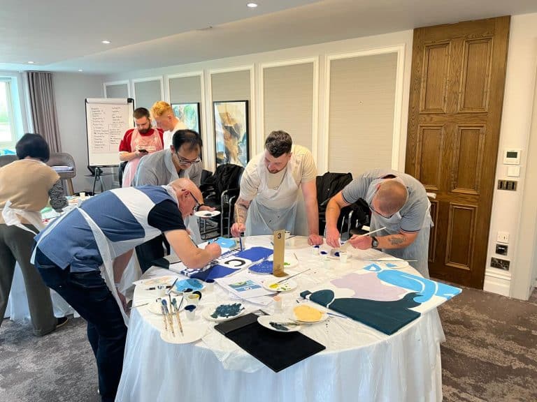 Delegates painting canvases as part of Orangeworks team activity called The Big Picture.