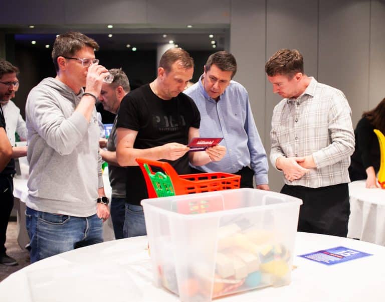 Delegates enjoying Orangeworks Chain Reaction challenge - working together to build a series of contraptions.
