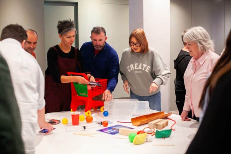 Delegates enjoying Orangeworks Chain Reaction challenge - working together to build a series of contraptions.