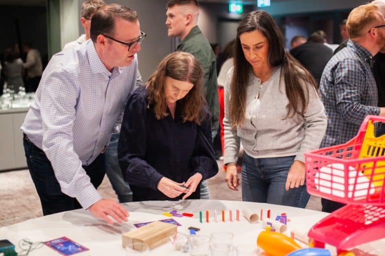 Delegates enjoying Orangeworks Chain Reaction challenge - working together to build a series of contraptions.