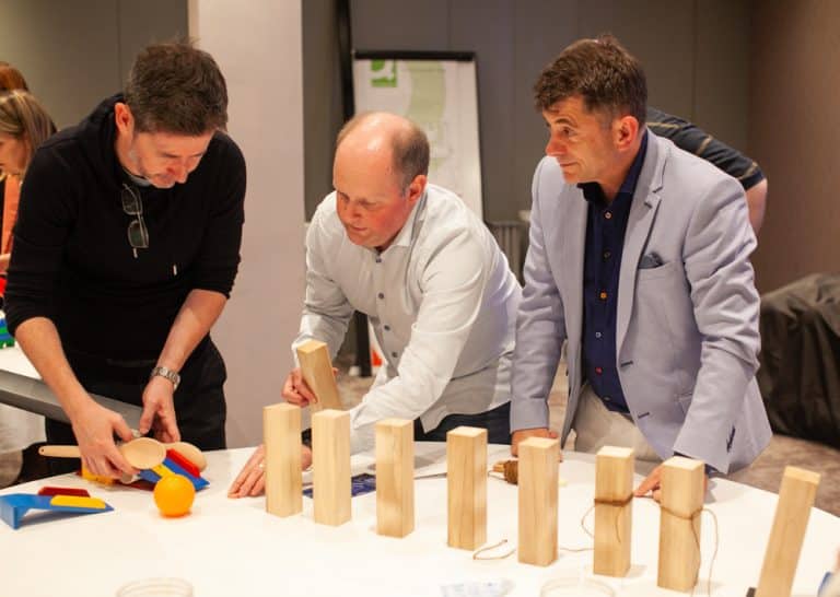 Delegates enjoying Orangeworks Chain Reaction challenge - working together to build a series of contraptions.