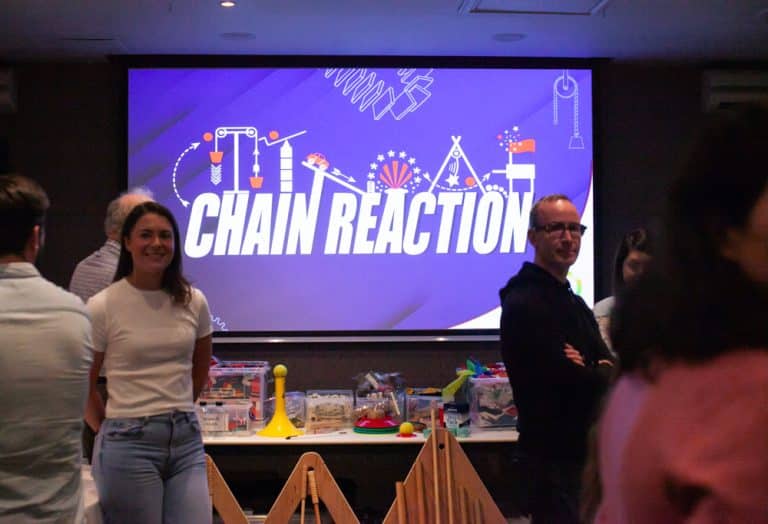 Delegates enjoying Orangeworks Chain Reaction challenge - working together to build a series of contraptions.