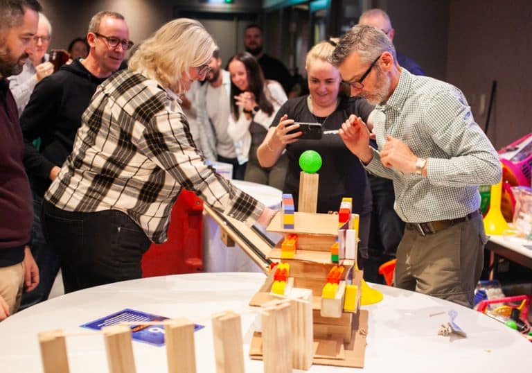 Delegates enjoying Orangeworks Chain Reaction challenge - working together to build a series of contraptions.