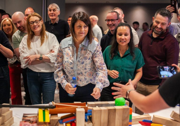 Delegates enjoying Orangeworks Chain Reaction challenge - working together to build a series of contraptions.