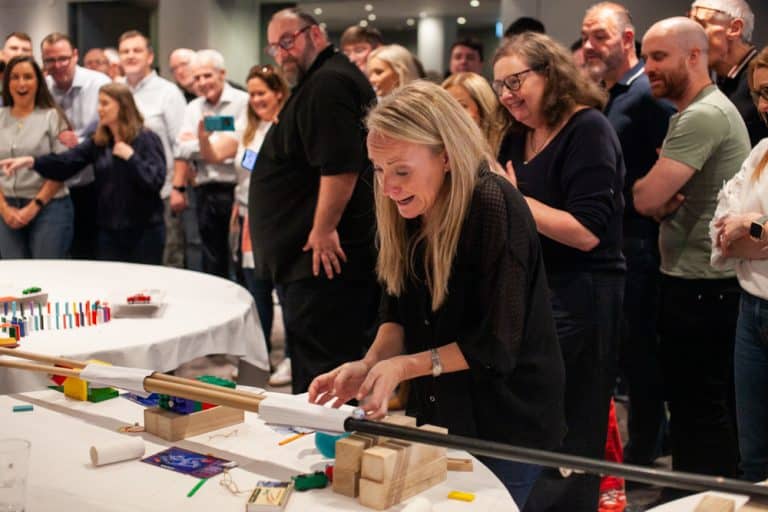 Delegates enjoying Orangeworks Chain Reaction challenge - working together to build a series of contraptions.