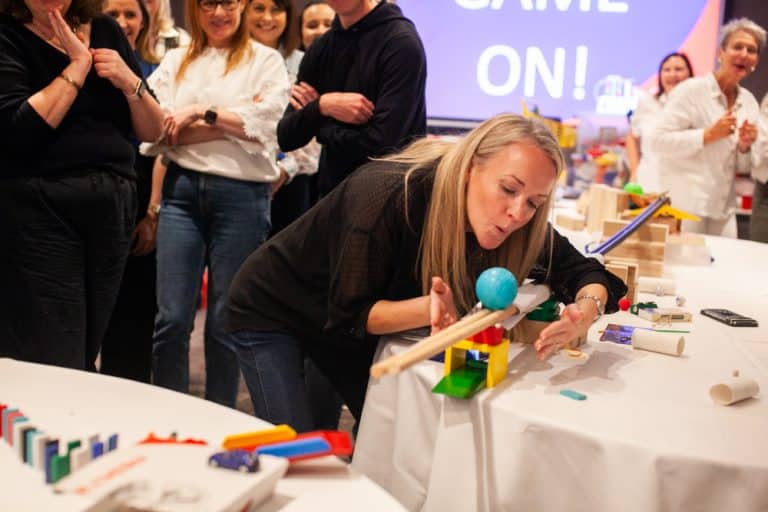 Delegates enjoying Orangeworks Chain Reaction challenge - working together to build a series of contraptions.