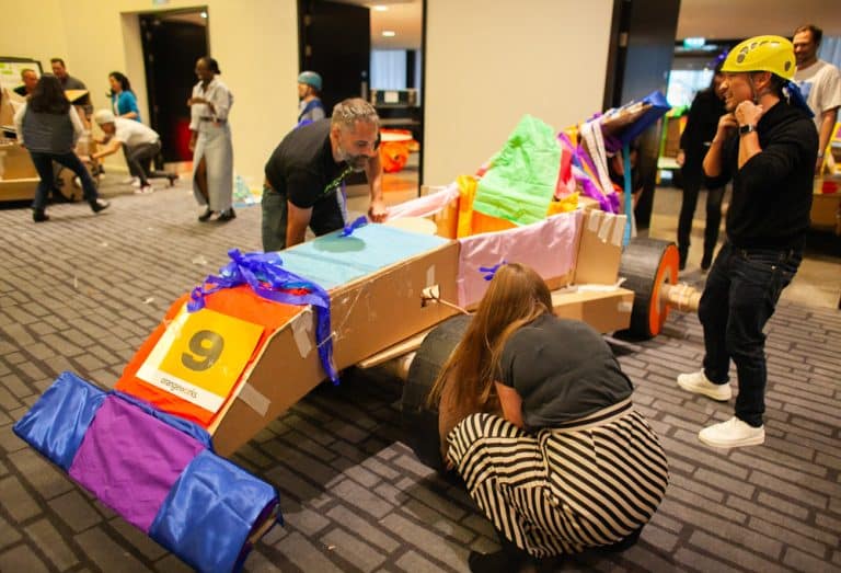 Delegates enjoying Orangeworks corporate team building challenge called Flat Out Formula where they build full size f1 cars from cardboard.