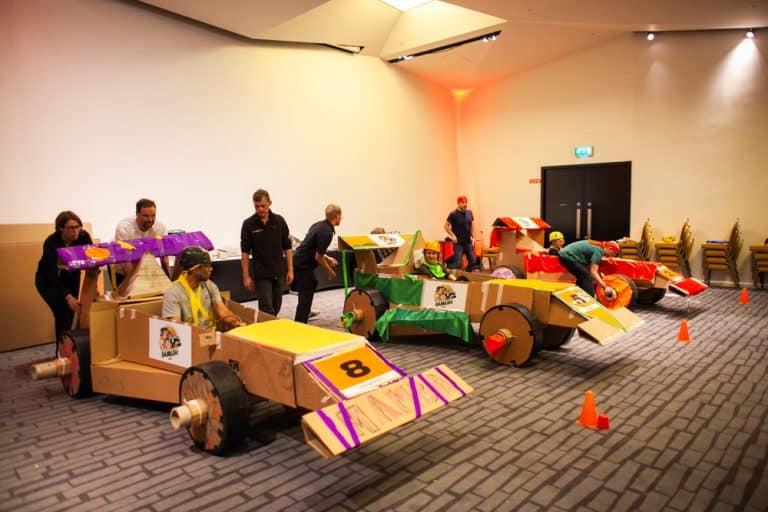 Delegates enjoying Orangeworks corporate team building challenge called Flat Out Formula where they build full size f1 cars from cardboard.