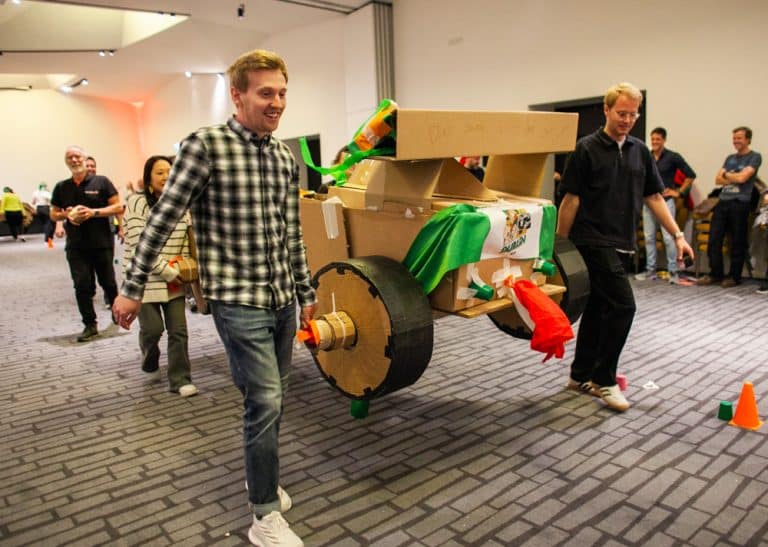 Delegates enjoying Orangeworks corporate team building challenge called Flat Out Formula where they build full size f1 cars from cardboard.
