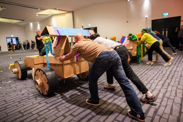 Delegates enjoying Orangeworks corporate team building challenge called Flat Out Formula where they build full size f1 cars from cardboard.