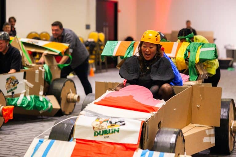 Delegates enjoying Orangeworks corporate team building challenge called Flat Out Formula where they build full size f1 cars from cardboard.