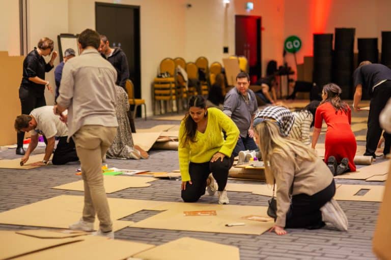 Delegates enjoying Orangeworks corporate team building challenge called Flat Out Formula where they build full size f1 cars from cardboard.