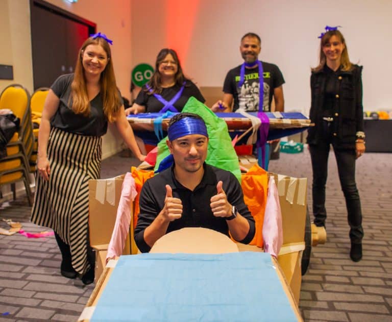 Delegates enjoying Orangeworks corporate team building challenge called Flat Out Formula where they build full size f1 cars from cardboard.