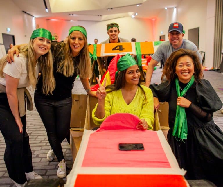 Delegates enjoying Orangeworks corporate team building challenge called Flat Out Formula where they build full size f1 cars from cardboard.