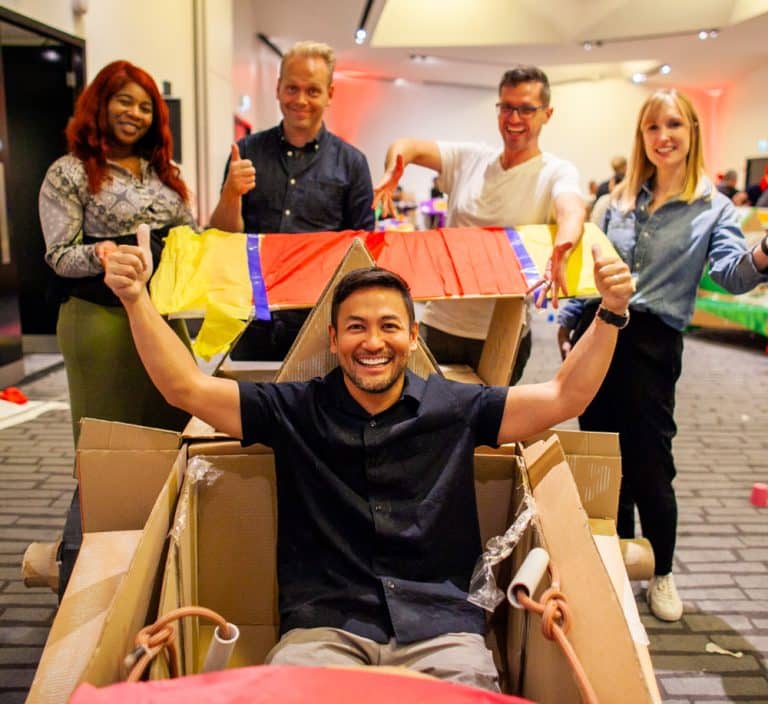 Delegates enjoying Orangeworks corporate team building challenge called Flat Out Formula where they build full size f1 cars from cardboard.