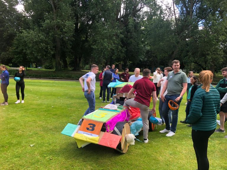 Delegates enjoying Orangeworks corporate team building challenge called Flat Out Formula where they build full size f1 cars from cardboard.