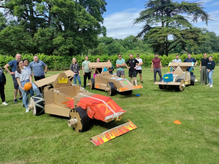 Delegates enjoying Orangeworks corporate team building challenge called Flat Out Formula where they build full size f1 cars from cardboard.