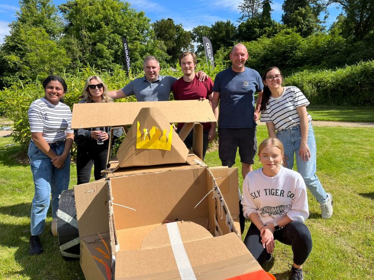 Delegates enjoying Orangeworks corporate team building challenge called Flat Out Formula where they build full size f1 cars from cardboard.