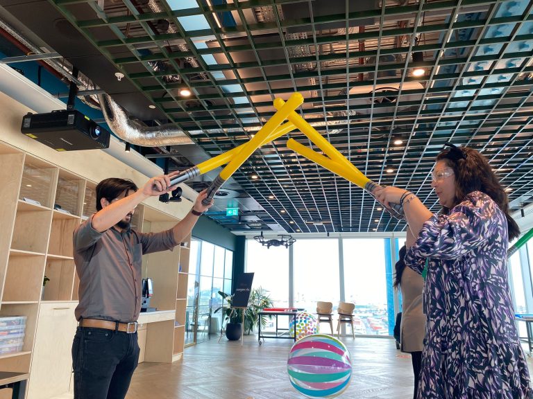 Delegates participating in one of Orangeworks fun team development activities called Drone Control. The aim of the activity is to successfully fly drones through man-made obstacles.