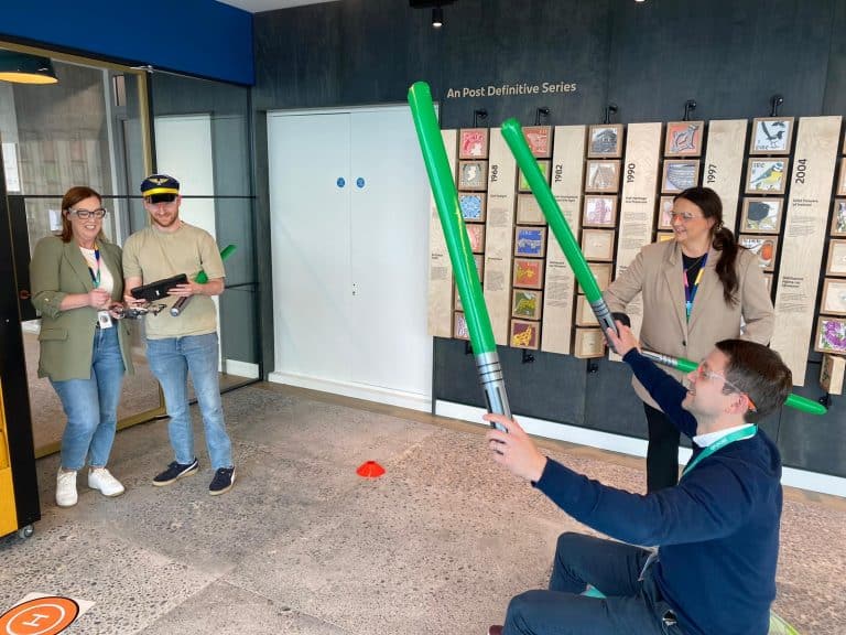 Delegates participating in one of Orangeworks fun team development activities called Drone Control. The aim of the activity is to successfully fly drones through man-made obstacles.