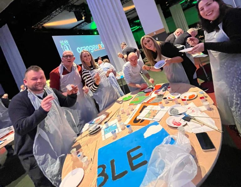 Delegates painting canvases as part of Orangeworks team activity called The Big Picture.