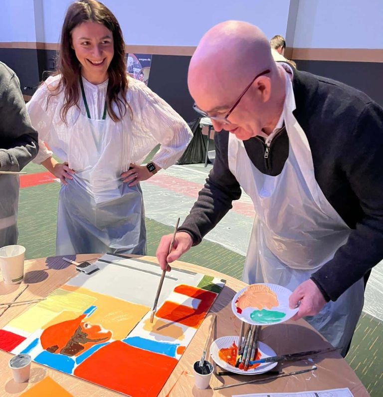 Delegates painting canvases as part of Orangeworks team activity called The Big Picture.