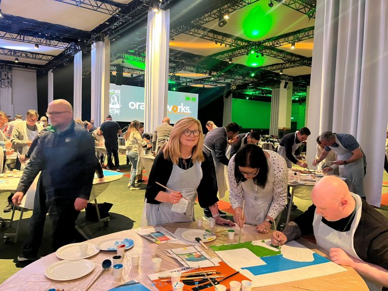 Delegates painting canvases as part of Orangeworks team activity called The Big Picture.