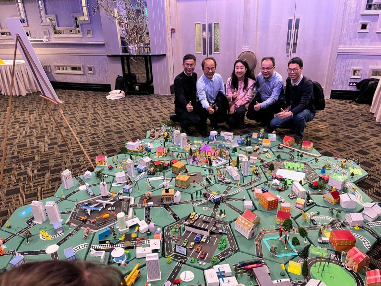 Delegates showcasing their miniature city that they built as part of Orangeworks creative construction based team activity called City Build.