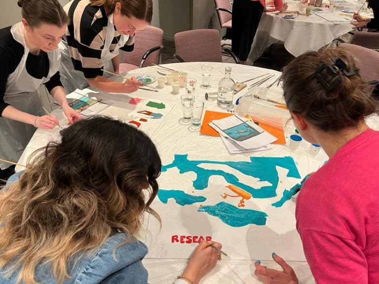 Delegates painting canvases as part of Orangeworks team activity called The Big Picture.