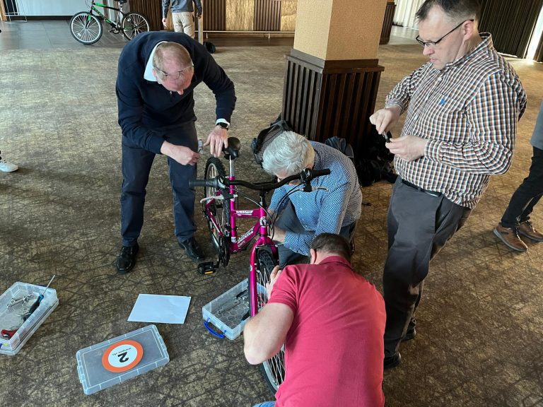 Delegates taking part in Orangeworks csr charity based activity where they build bikes and donate them to local charities.