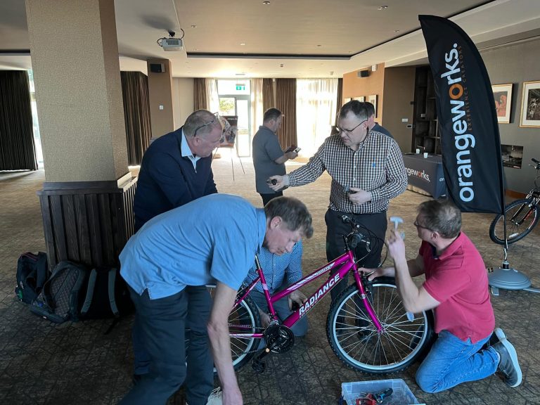Delegates taking part in Orangeworks csr charity based activity where they build bikes and donate them to local charities.